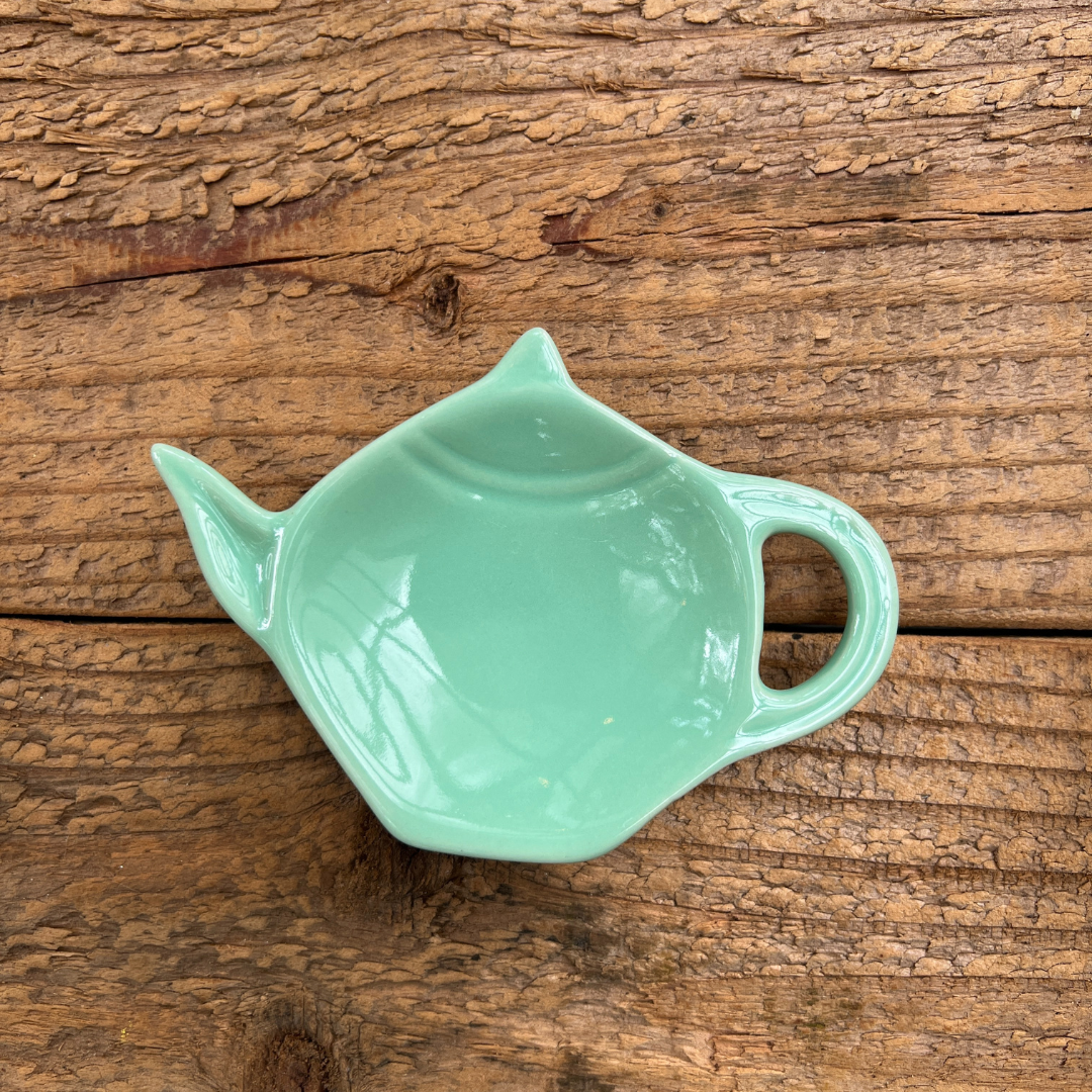 light green spoon rest on a rustic wooden board