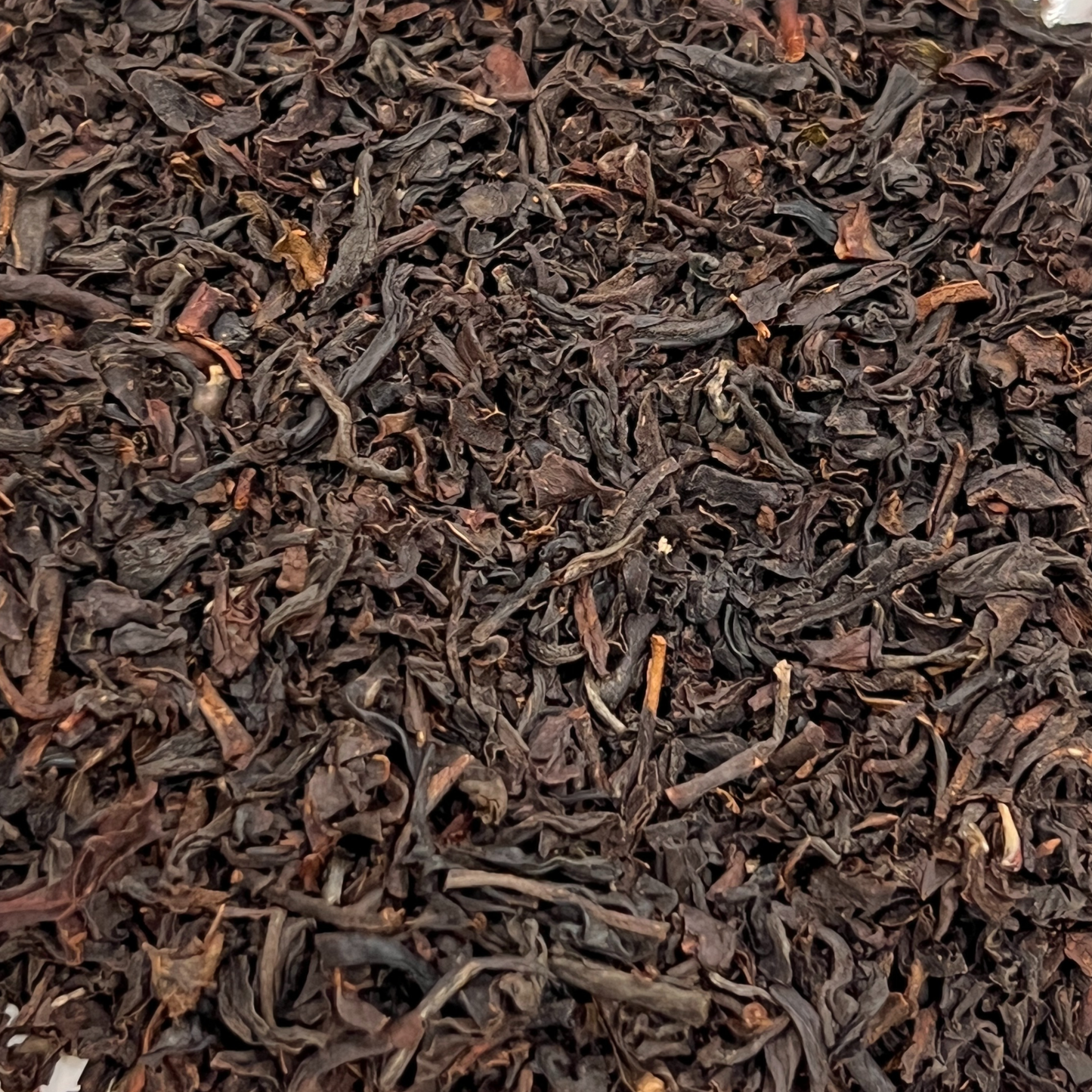 Close-up of dark brown dried tea leaves, black tea